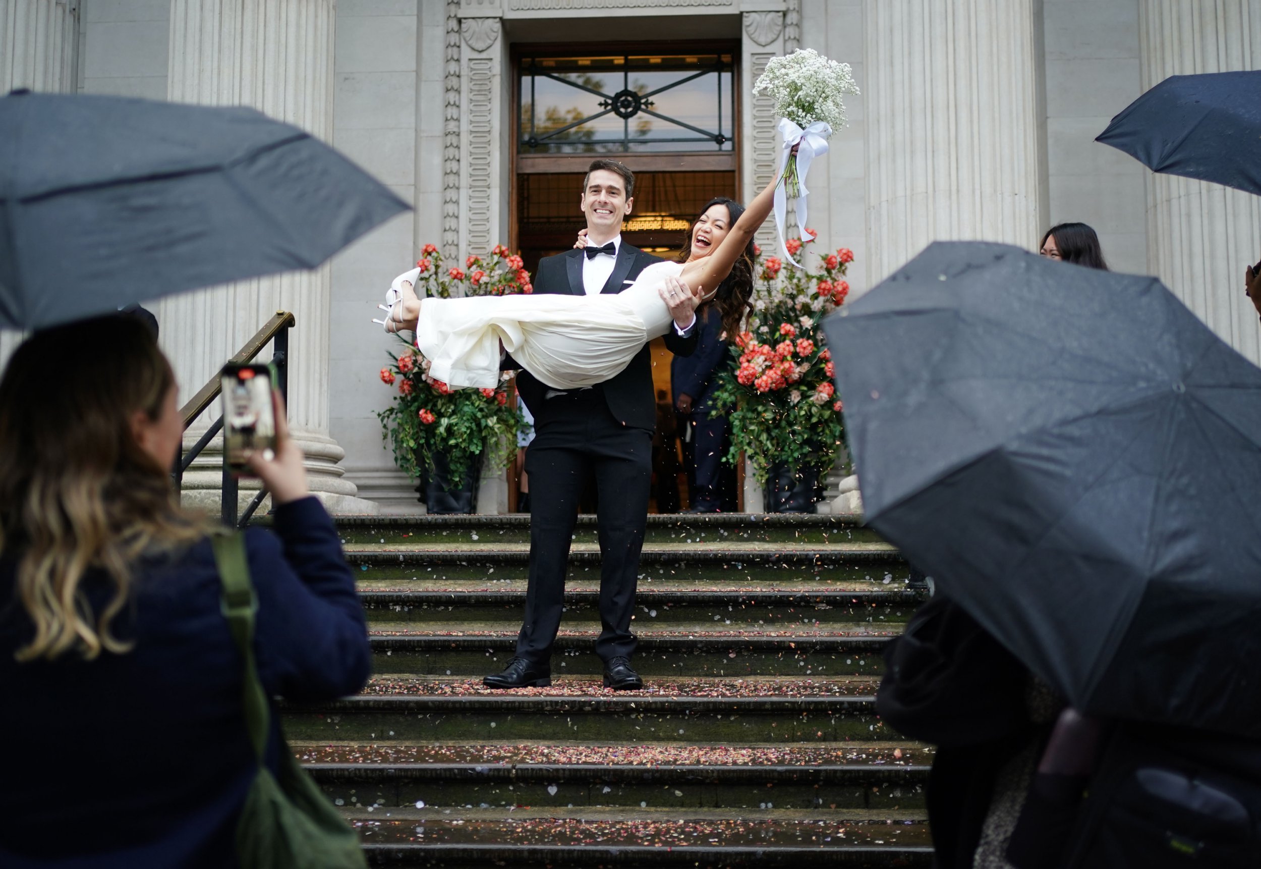 Newly married Australian couple Brad, Standfield, 31 lifts his new wife Priscilla 32, on the steps of Old Marylebone Town Hall in London